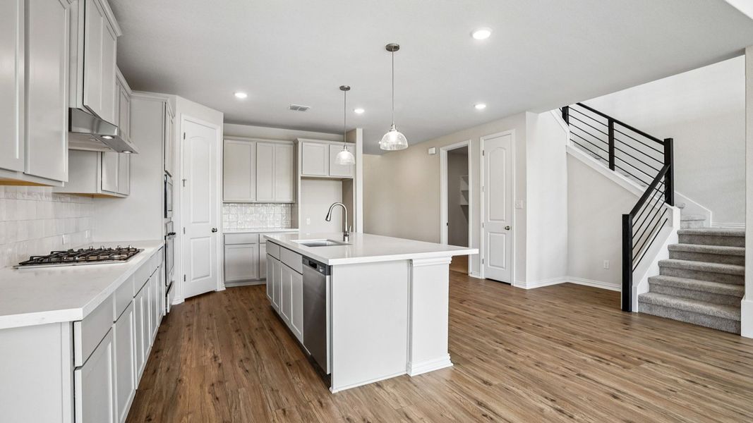Modern Kitchen Features Built-in Appliances, Pendant Island, and Center Island