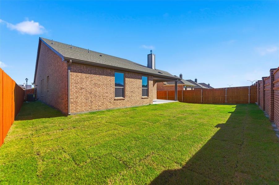 Back of house with a patio, a fenced backyard, brick siding, a shingled roof, and a chimney