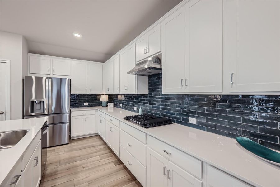 You will be in awe of the bright, white cabinets, quartz countertops, striking backsplash, and the modern appliances including a 5-burner gas stove! This kitchen is sure to please everyone!