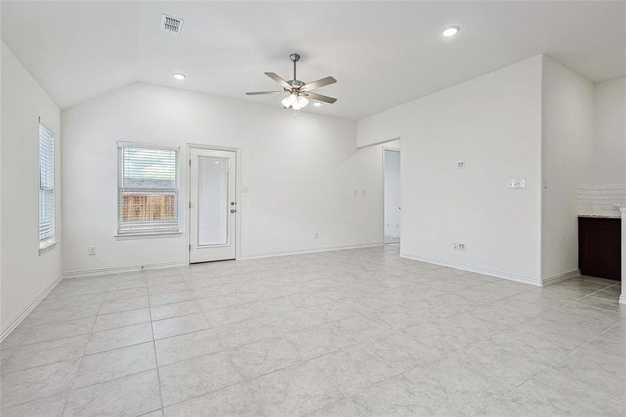 Tiled empty room featuring ceiling fan and lofted ceiling