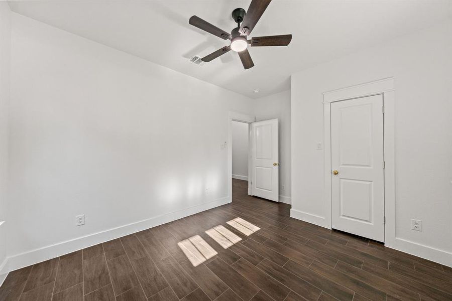 Unfurnished bedroom with wood tiled floors and ceiling fan Unfurnished bedroom with wood tiled floors and ceiling fan