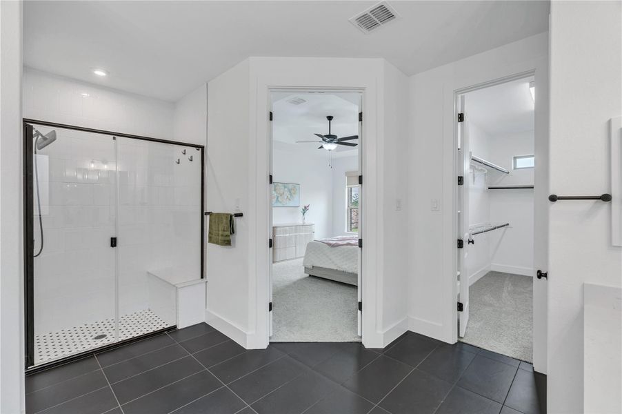 A well-appointed primary bathroom features a spacious walk-in shower and convenient access to the primary bedroom.