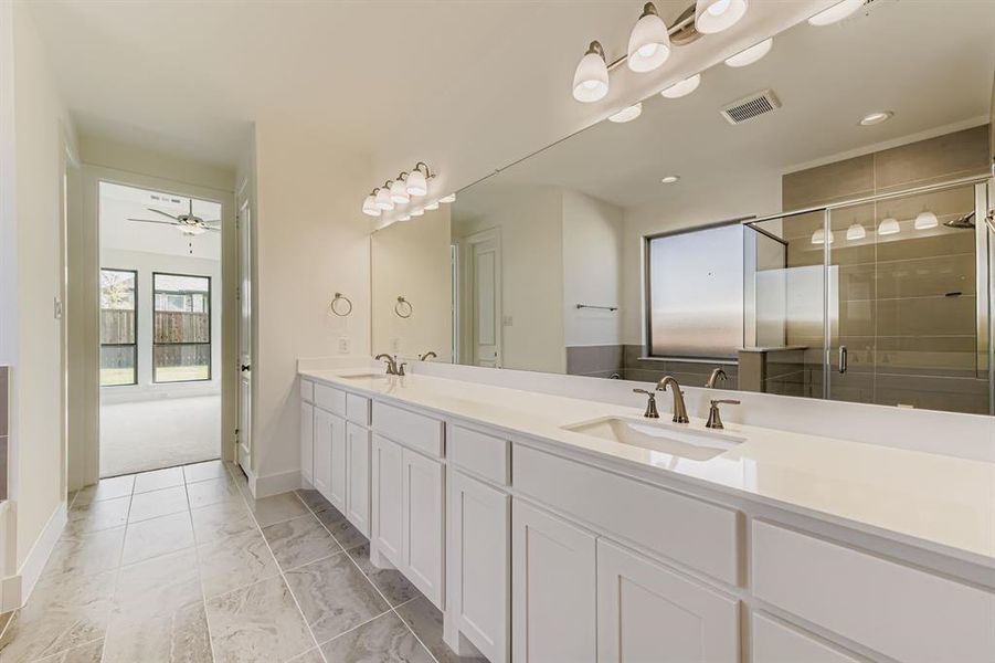 Bathroom with double vanity, a shower stall, and a ceiling fan Bathroom with double vanity, a shower stall, and a ceiling fan