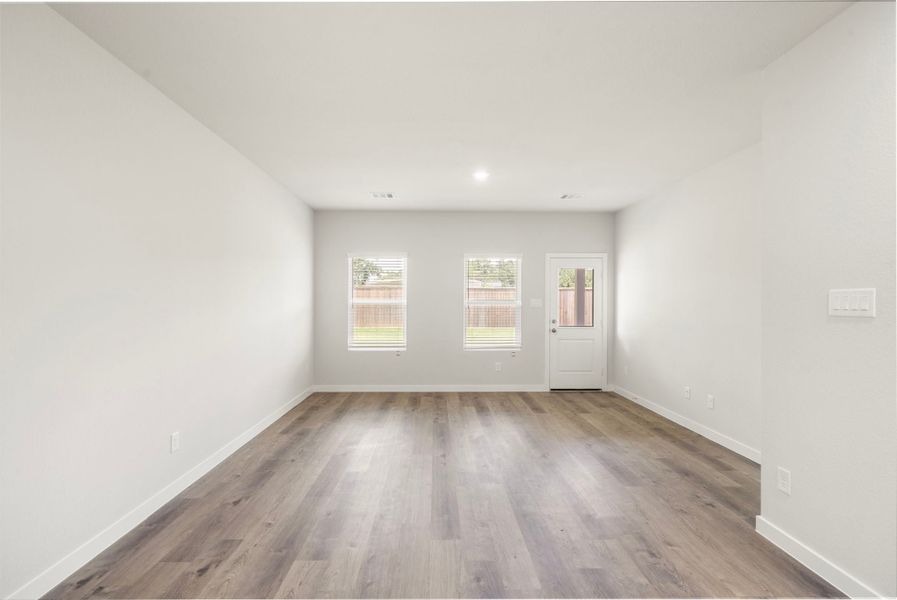 A room with a wood floor and white walls.