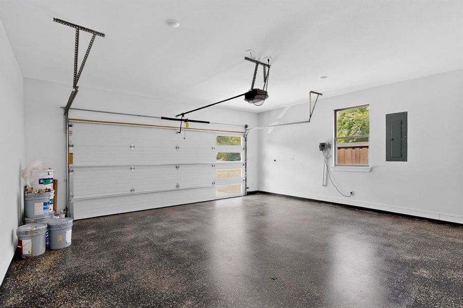 Garage featuring electric panel and a garage door opener Garage featuring electric panel and a garage door opener