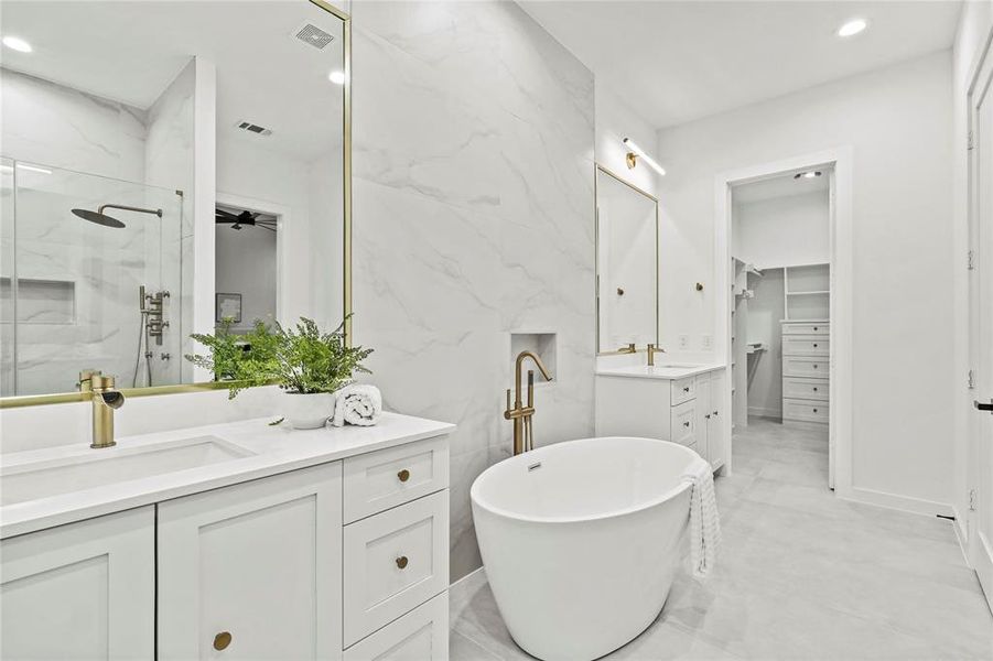 Bathroom featuring tile walls, shower with separate bathtub, tile patterned floors, and dual bowl vanity