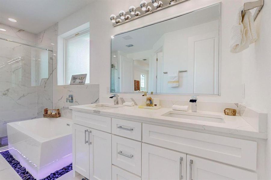 Bathroom with plenty of natural light, shower with separate bathtub, and vanity