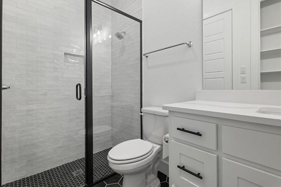 Bathroom with vanity, a stall shower, a textured wall, and tile patterned floors Bathroom with vanity, a stall shower, a textured wall, and tile patterned floors