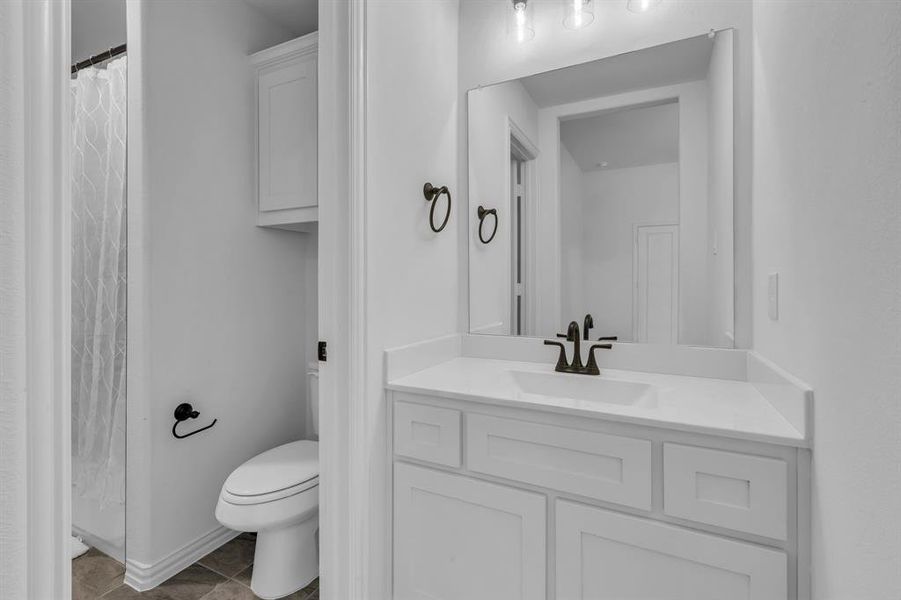 Bathroom featuring tile patterned floors, toilet, and vanity