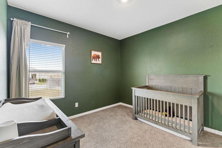 Bedroom with soft carpet and a serene view through the window.