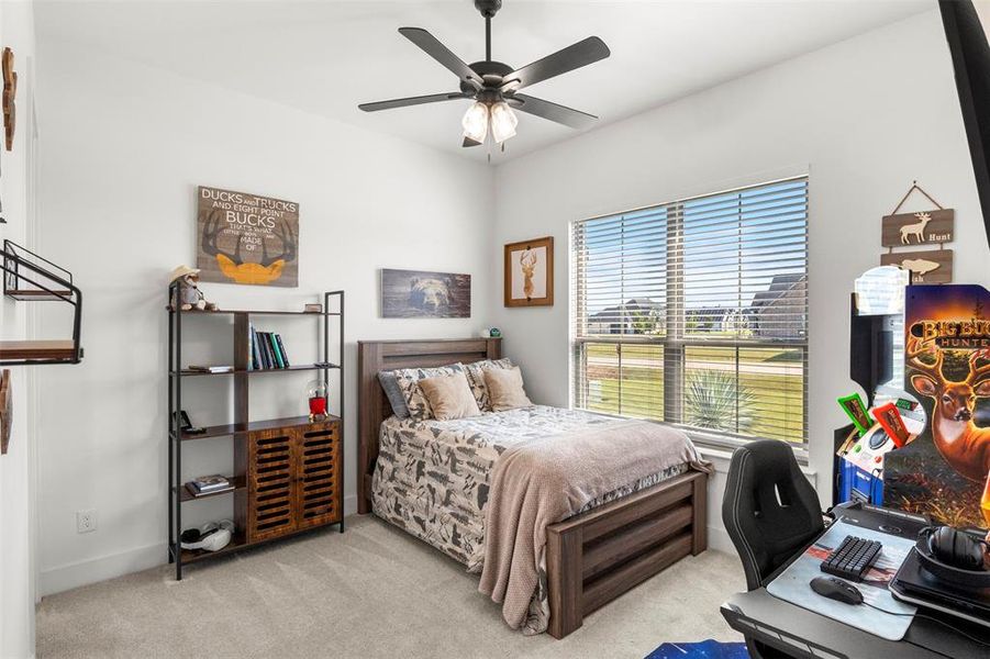 Bedroom with carpet floors and ceiling fan. Large walk in closet