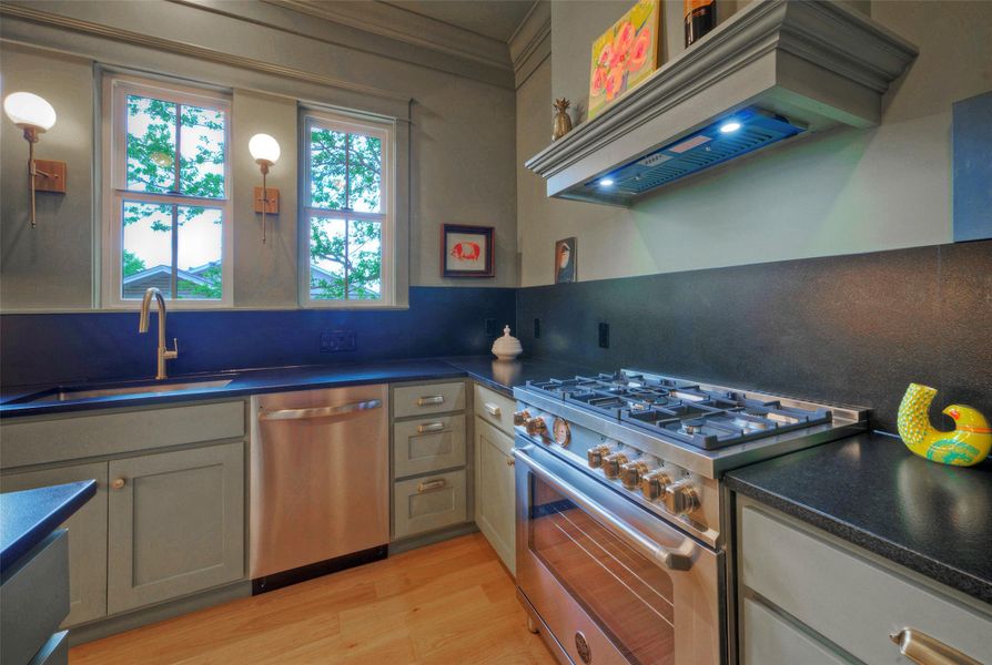 Culinary delights await in this well-appointed kitchen, featuring a professional-grade dual fuel range and rich wood flooring.