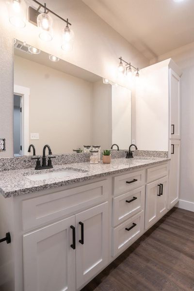 Full bath with double vanity and wood finished floors Full bath with double vanity and wood finished floors