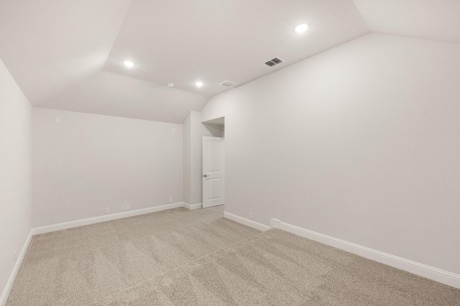 Empty room with vaulted ceiling, recessed lighting, beige carpet, and white walls