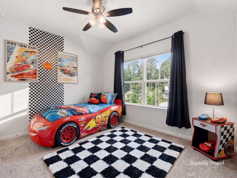 Secondary bedroom with a vaulted ceiling, ceiling fan, and a window framing peaceful wooded views. Carpeted and bright, with a playful checkered accent on the wall. This photo has been digitally staged to illustrate the possibilities of the home's aesthetic and potential design. Some furnishings and décor shown are for visual inspiration.