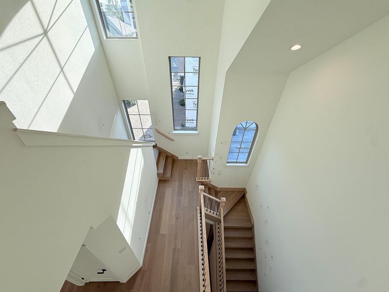 Flooded with natural sunlight from thoughtfully placed, unique geometric windows, the staircase leading to the third-floor loft and two bedrooms, is a breath of fresh air.