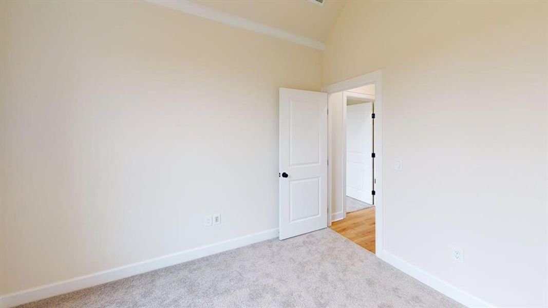 Spare room featuring carpet flooring and high vaulted ceiling