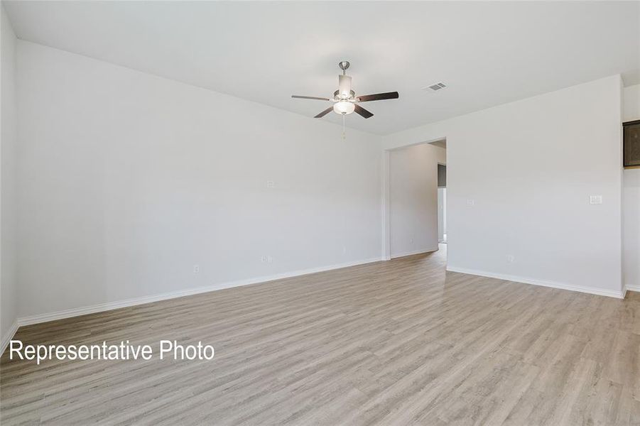 Empty room with ceiling fan and light hardwood / wood-style flooring