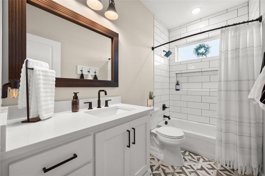 Full bathroom featuring tile flooring, shower / bath combination with curtain, vanity, and toilet