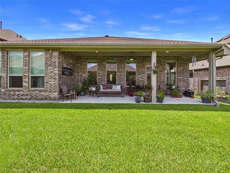 Outside you can sit under this large covered patio with a ceiling fan to enjoy your back yard.
