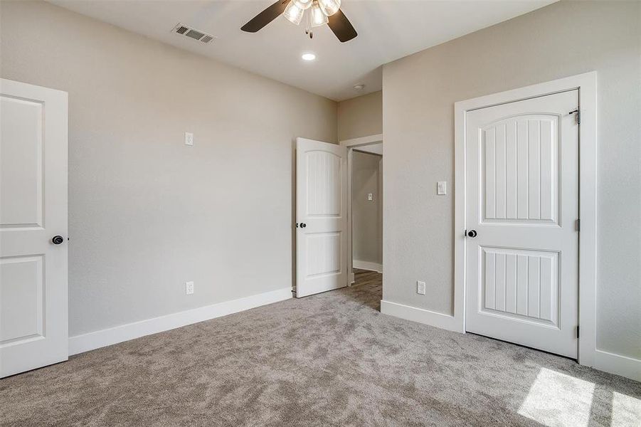 Unfurnished bedroom featuring a closet, ceiling fan, and light colored carpet