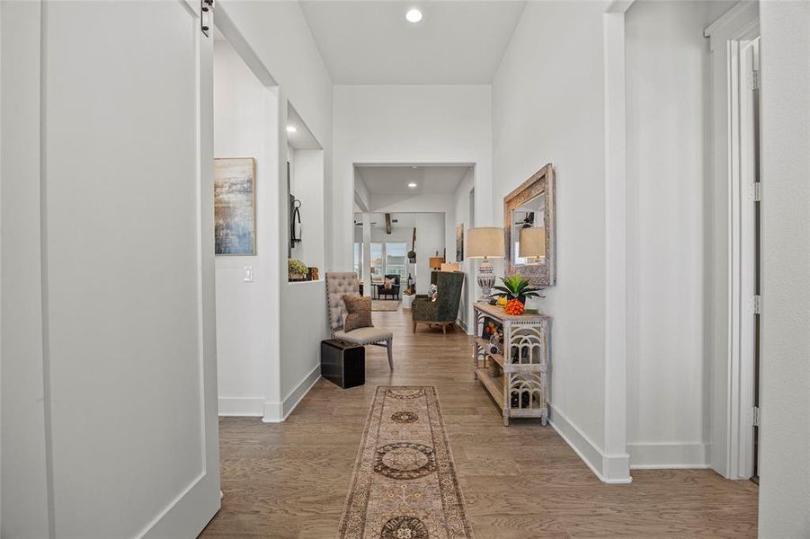 Hallway with a barn door and hardwood / wood-style floors