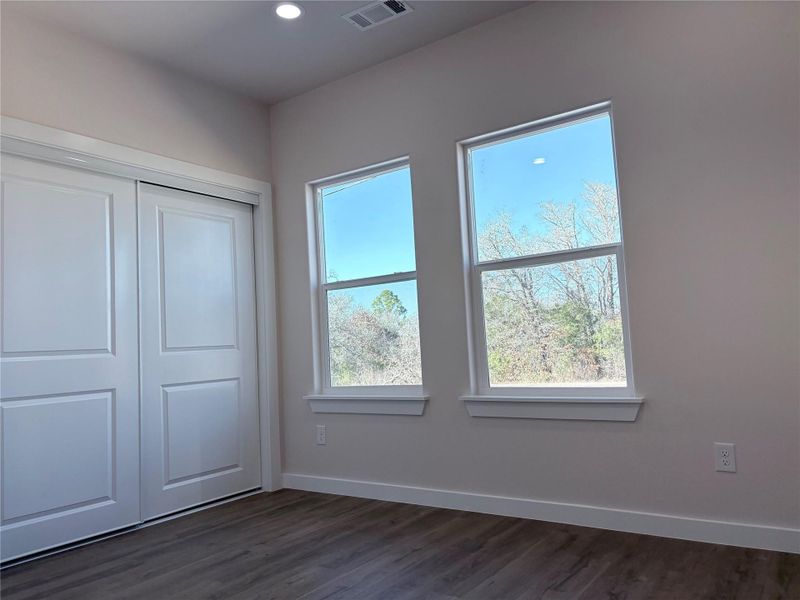 Unfurnished primary bedroom with dark wood finished floors, a closet, and recessed lighting