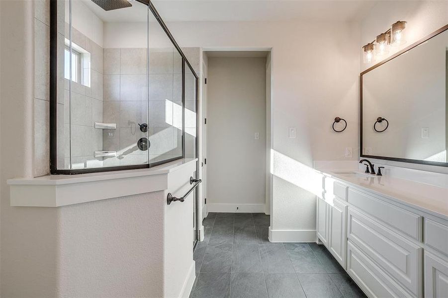 Bathroom featuring vanity and tiled shower