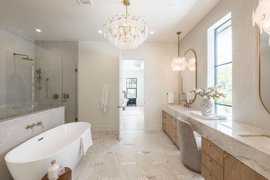A spa-worthy sanctuary anchored by a sculptural soaking tub and wrapped in soft, textural finishes. The glass-enclosed shower with statement tilework creates a refined contrast, offering a private escape designed for restoration and calm.
