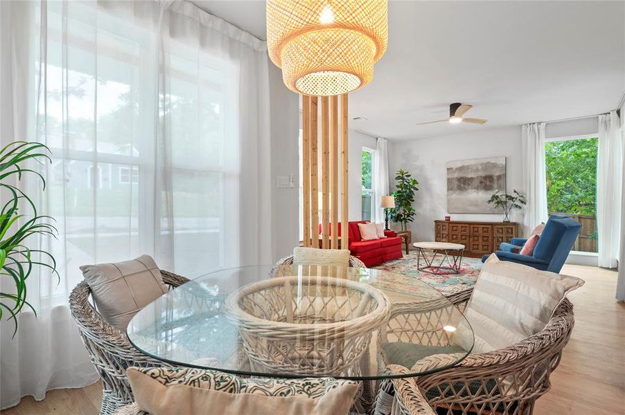 Dining area with a healthy amount of sunlight, ceiling fan, and light wood-type flooring