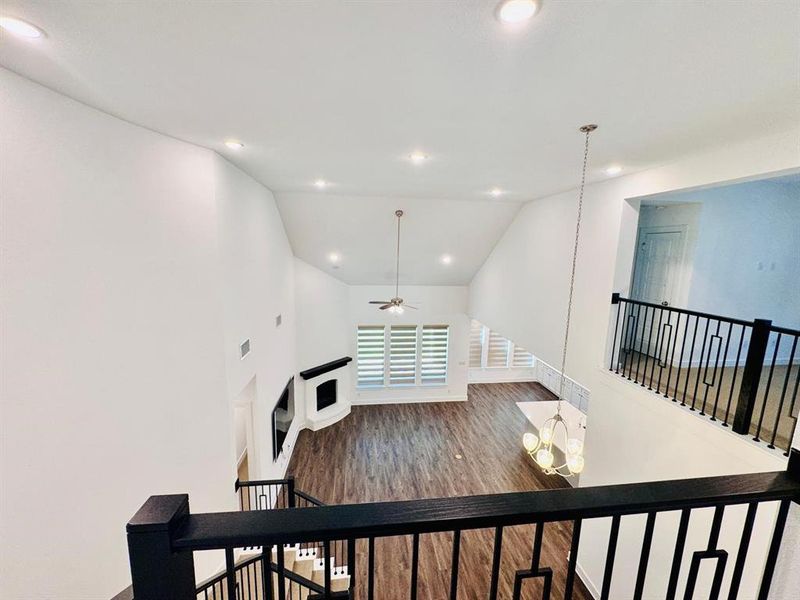 Living room featuring dark wood-type flooring, vaulted ceiling, and ceiling fan