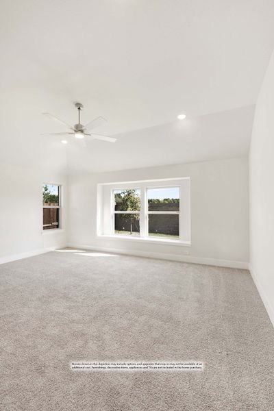 Empty bedroom with vaulted ceiling, ceiling fan, carpet flooring, and two windows with backyard view Empty bedroom with vaulted ceiling, ceiling fan, carpet flooring, and two windows with backyard view