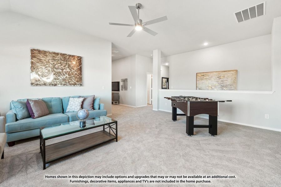 Bonus room with blue sofa, foosball table, ceiling fan, and carpet flooring