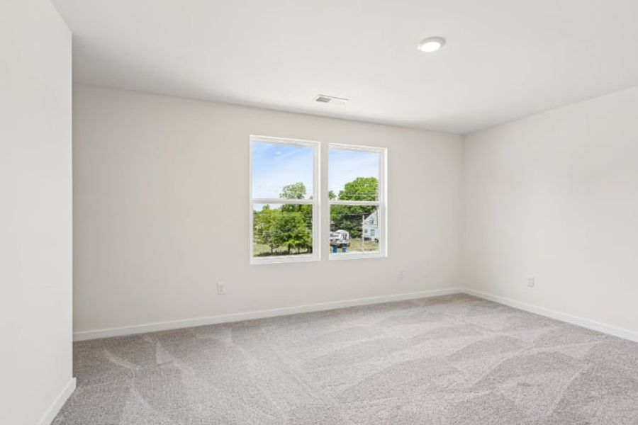 A room with a window and a carpet.