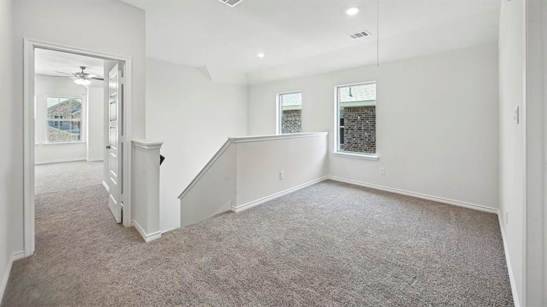 Empty room featuring light colored carpet, plenty of natural light, and recessed lighting