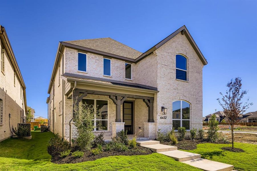 View of front facade with a front yard, a porch, brick siding, and roof with shingles View of front facade with a front yard, a porch, brick siding, and roof with shingles