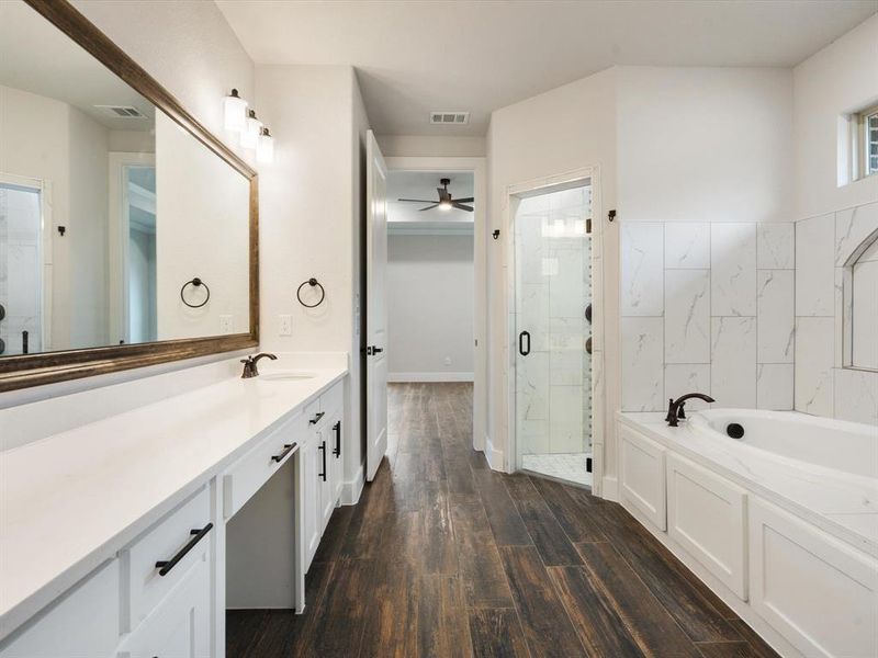 Bathroom featuring hardwood / wood-style floors, vanity, separate shower and tub, and ceiling fan