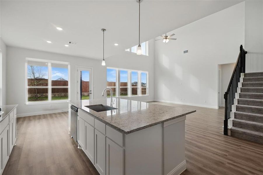 Kitchen featuring baseboards, a sink, a ceiling fan, and dark wood-style floors Kitchen featuring baseboards, a sink, a ceiling fan, and dark wood-style floors