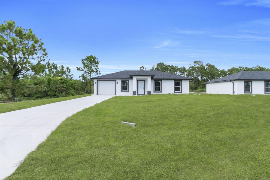 Front exterior of a new home in , Lehigh Acres, FL, highlighting curb appeal (Image 20).