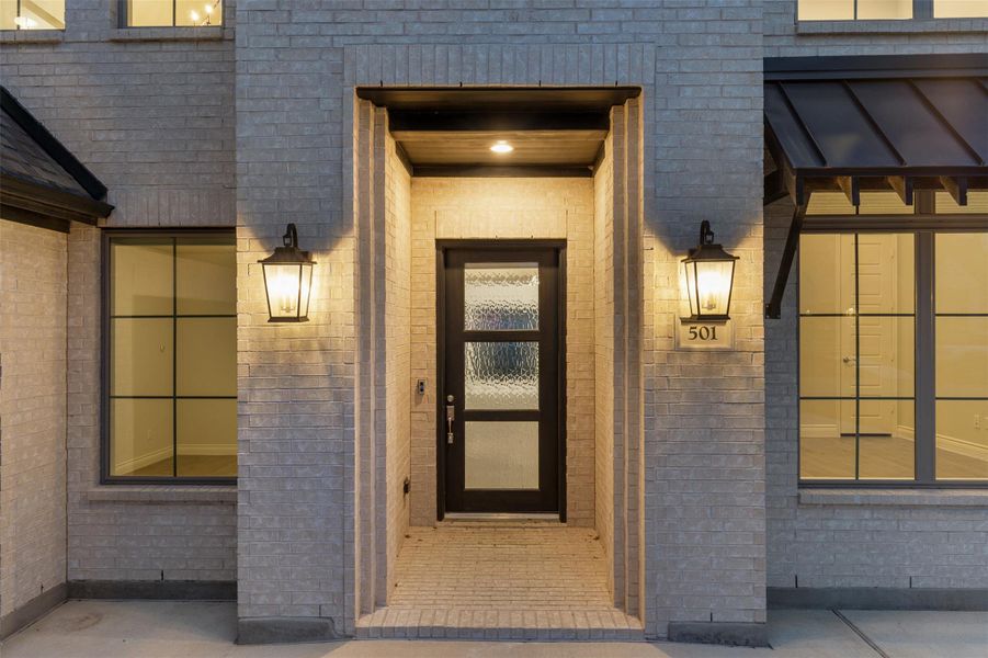 Doorway to property featuring brick siding