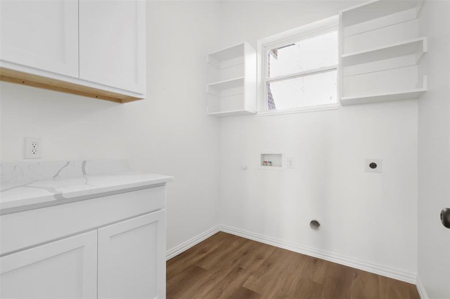 Laundry room featuring electric dryer hookup, cabinets, gas dryer hookup, dark wood-type flooring, and washer hookup