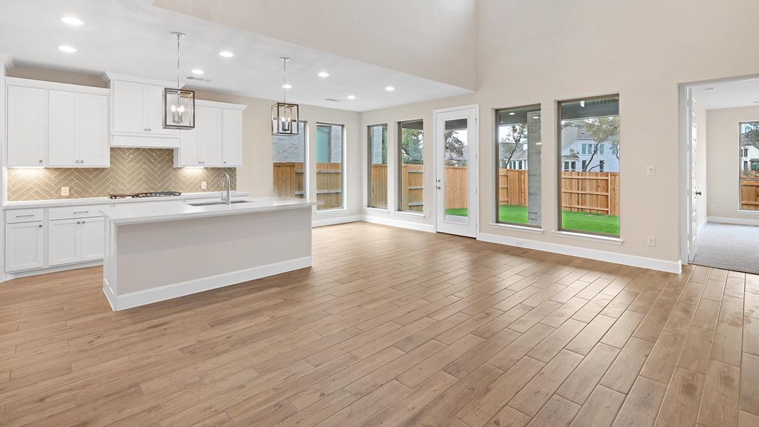Kitchen with decorative light fixtures, white cabinetry, decorative backsplash, recessed lighting, and open floor plan