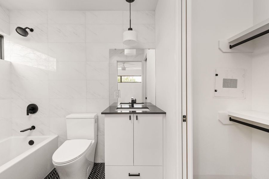 Full bath with vanity, tile walls,  shower combination, and tile patterned floors