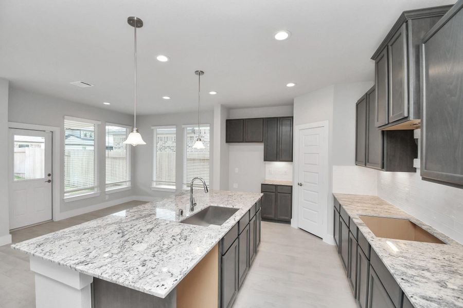 The kitchen is a culinary haven, featuring granite countertops, a tile backsplash, stainless steel appliances, 42” upper cabinets, and undercabinet lighting. The kitchen is a culinary haven, featuring granite countertops, a tile backsplash, stainless steel appliances, 42” upper cabinets, and undercabinet lighting.