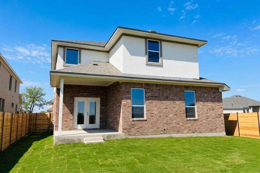 Back of house featuring french doors, a fenced backyard, a patio, and brick siding
