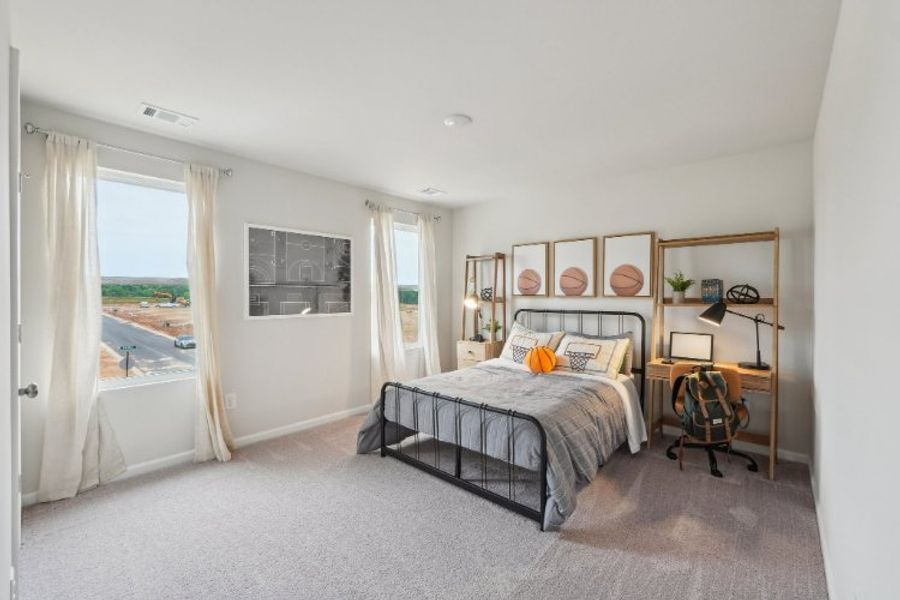 A bedroom with a bed and a desk.