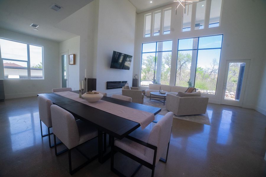 Designed for effortless entertaining, the expansive dining area flows seamlessly into the main living space. Surrounded by towering windows, the entire floor plan is saturated in natural light, creating a vibrant and airy atmosphere for gatherings of any size