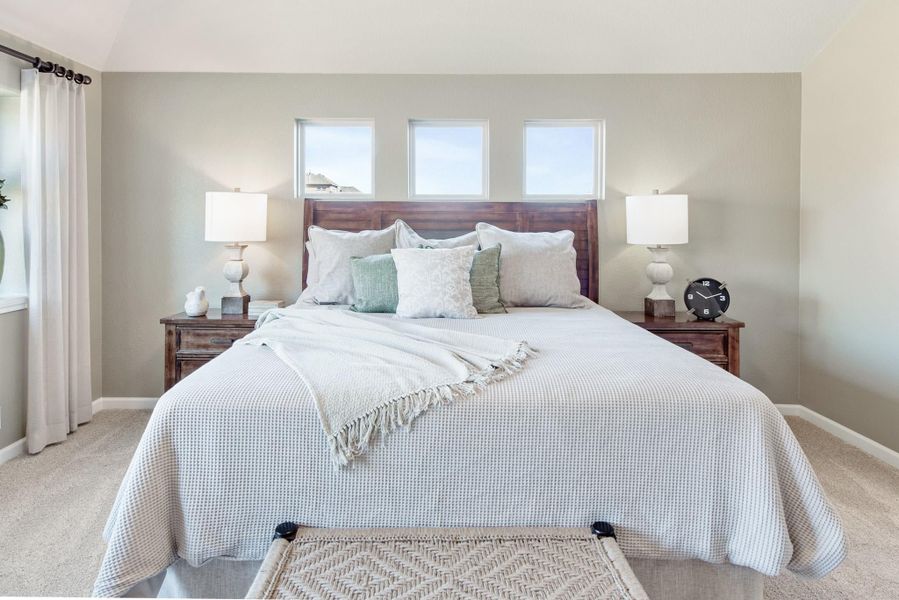 Bedroom with king bed, wood headboard, neutral bedding, and three small windows above the headboard Bedroom with king bed, wood headboard, neutral bedding, and three small windows above the headboard