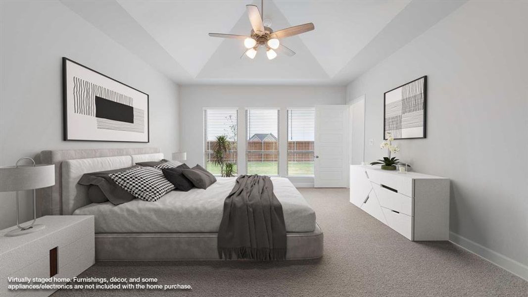 Bedroom with ceiling fan, a raised ceiling, carpet floors, and vaulted ceiling