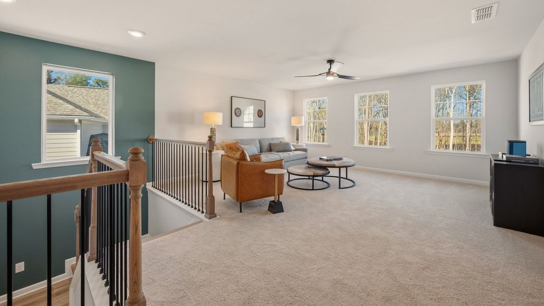 Spacious loft area with ceiling fan and carpet Spacious loft area with ceiling fan and carpet